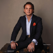 Richard van der Dys, founder of Vander Dys Fine Jewelers, posing with an exclusive collection of luxury watches and fine jewelry, including Patek Philippe timepieces and rare gemstones