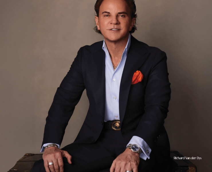 Richard van der Dys, founder of Vander Dys Fine Jewelers, posing with an exclusive collection of luxury watches and fine jewelry, including Patek Philippe timepieces and rare gemstones