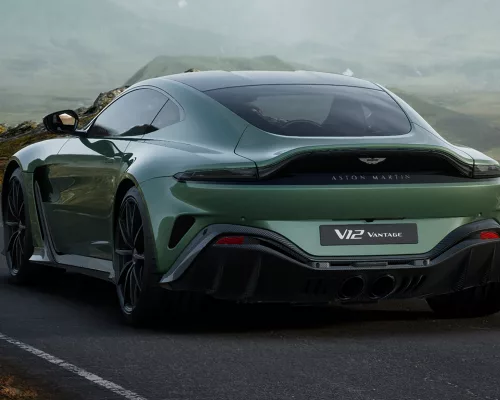 A side profile of the new Aston Martin Vantage parked outside an exclusive luxury estate