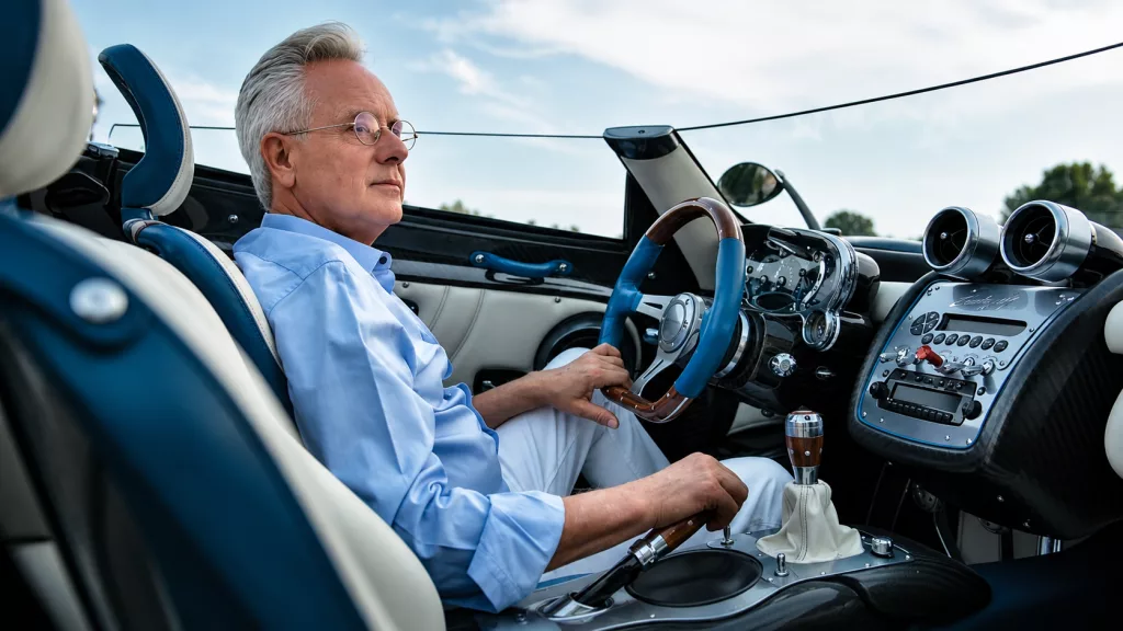Horacio Pagani standing alongside a Pagani Utopia hypercar