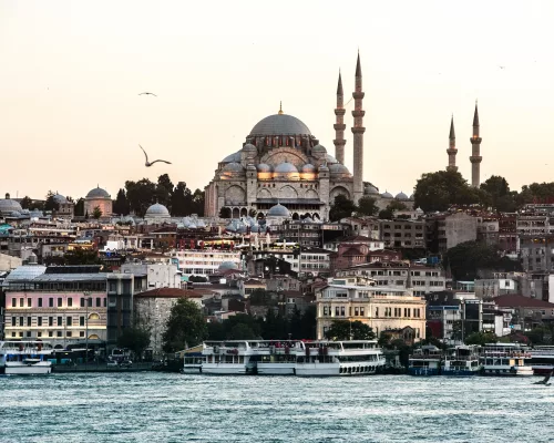 The historic skyline of Istanbul showing the Blue Mosque and Hagia Sophia during a golden sunset over the Bosphorus