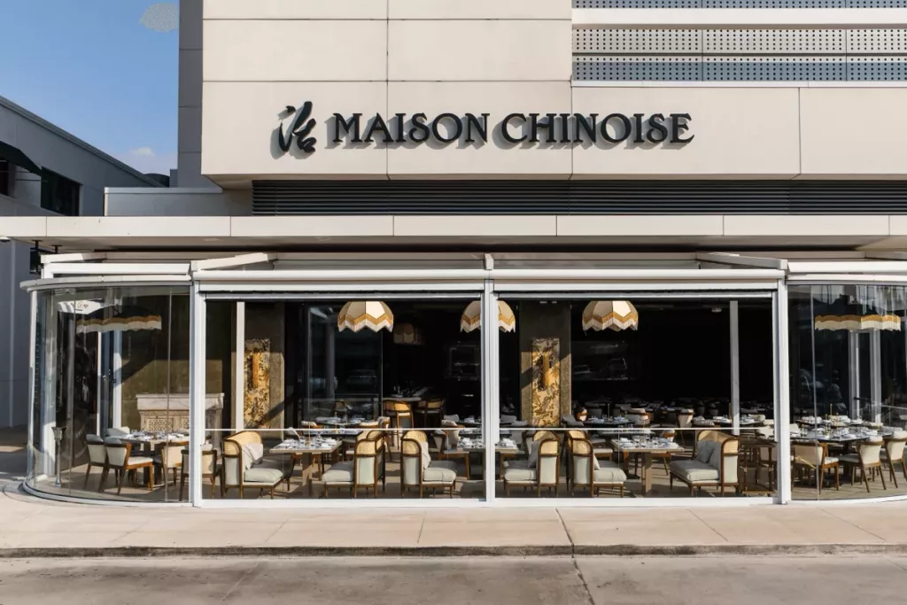 The luxurious interior dining room of Maison Chinoise in River Oaks Houston featuring warm ambient lighting